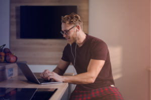 ragazzo in maglietta nera che lavora al pc da casa online